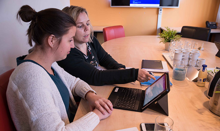 collega's werken samen achter laptop