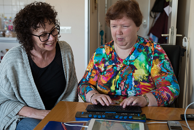 Client en begeleider werken samen met brailleregel