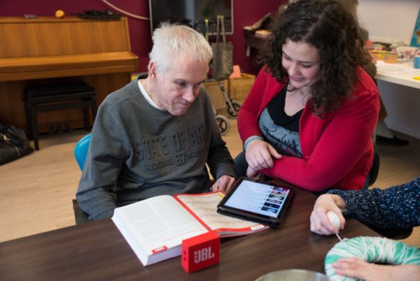 Client en begeleider luisteren samen naar muziek