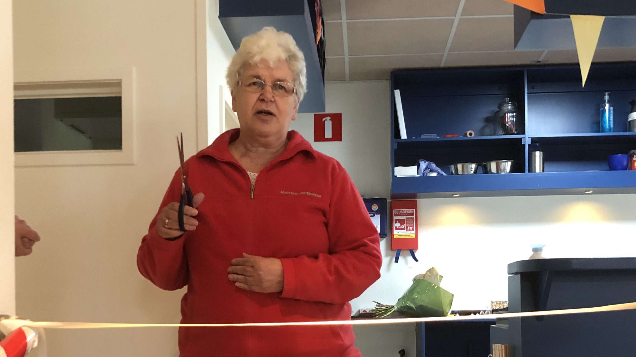Deelnemer knipt lint door