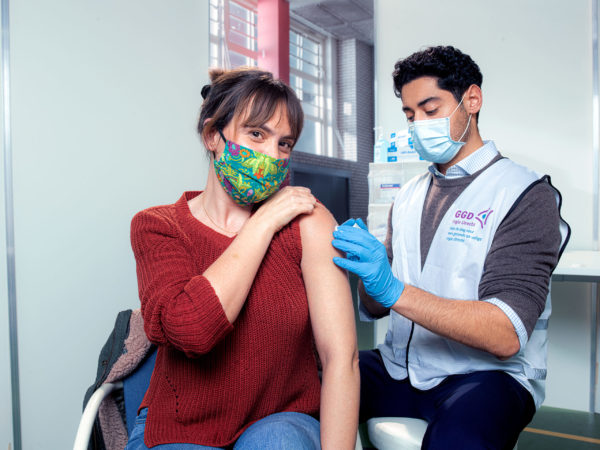 vaccinatie vrouw door zorgmedewerker