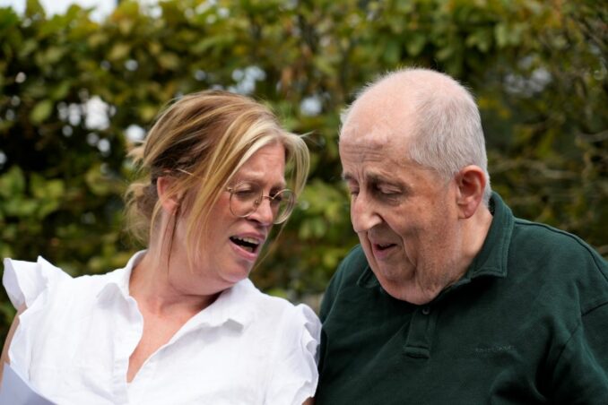Foto van medewerker Annemieke en bewoner Henk van het Bisschop Zwijsenplein, die samen een speech houden op de receptie ter ere van het 25-jarig jubileum.