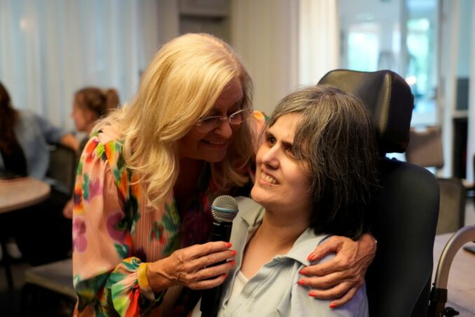 Foto van zangeres Corry Konings met cliënt Chantal Neijenhof, tijdens de feestavond.