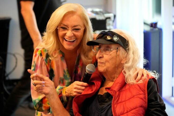 Foto van zangeres Corry Konings met cliënt mw. Maasen, tijdens de feestavond.