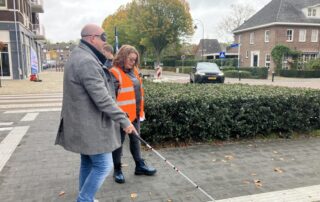 Bezoeker die de kans krijgt om zelf te lopen met de witte stok